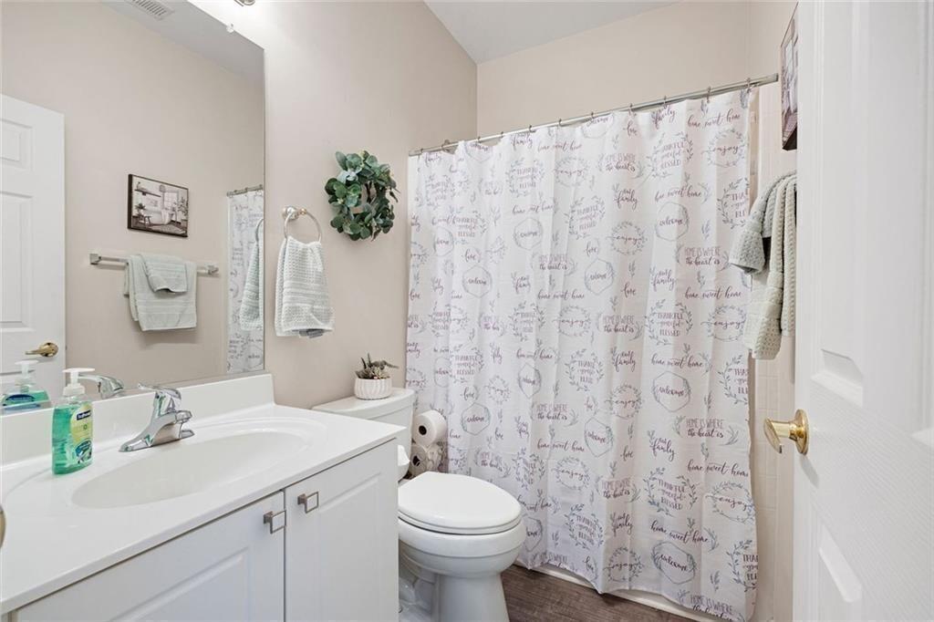 3807 Abbott Lane Southwest, Unit 15 Powder Springs, GA 30127 - Photo 26 of 32 a bathroom with a sink a toilet and a mirror