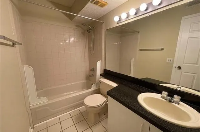 a bathroom with a granite countertop sink toilet a mirror and shower