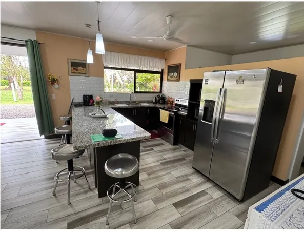 a kitchen with stainless steel appliances granite countertop a refrigerator a sink a stove and a refrigerator