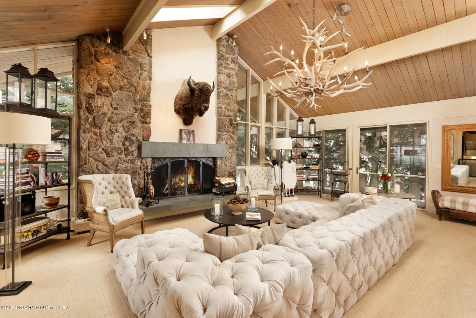 a living room with furniture a fireplace and a chandelier