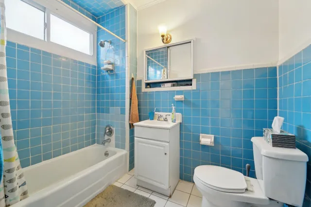 a bathroom with a sink a toilet a mirror a bathtub and shower