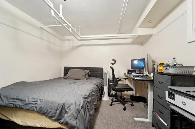 a bedroom with a bed and a desk