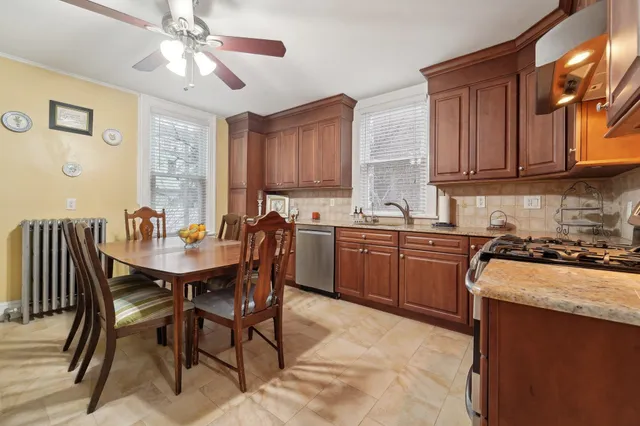 a kitchen with a stove a sink a dining table and chairs
