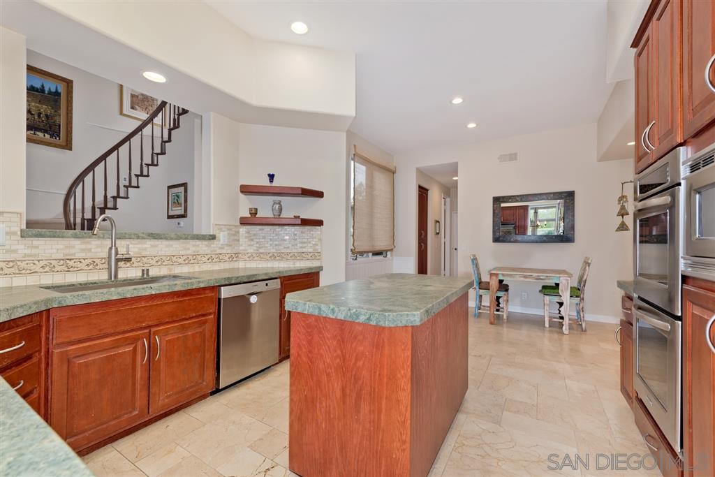 3138 Hamburg Square La Jolla, CA 92037 - Photo 7 of 25 a large kitchen with kitchen island a sink granite counter tops and a view of living room