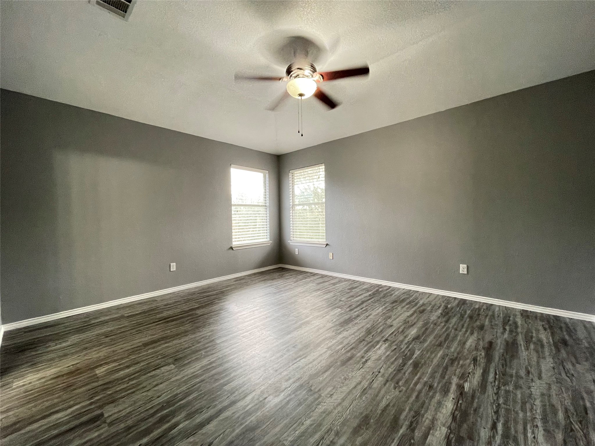 3638 Windhill Loop Round Rock, TX 78681 - Photo 21 of 32 Spacious room featuring wood-finish flooring, neutral gray wall tones, and white trim