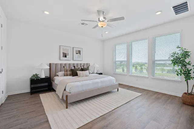 a spacious bedroom with a large bed and a large window