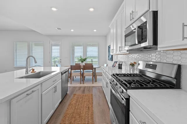 a kitchen with stainless steel appliances a sink stove and cabinets