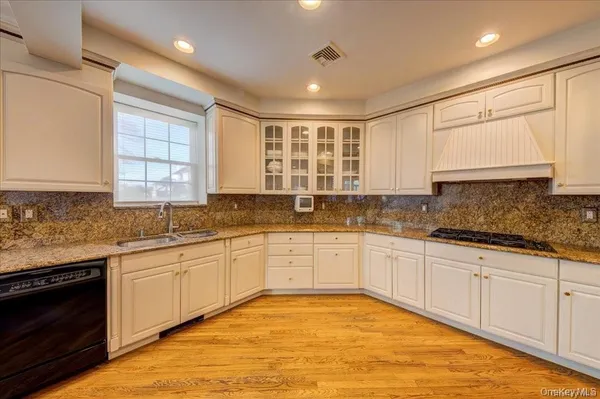 a large kitchen with stainless steel appliances granite countertop a stove sink and cabinets