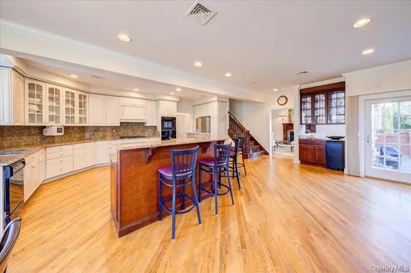 a living room with stainless steel appliances kitchen island granite countertop wooden floors and a view of living room