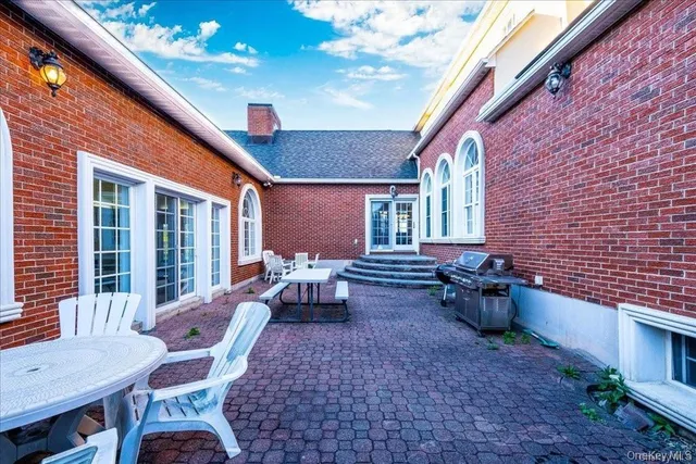 a view of a patio with couple of chairs and a fire pit