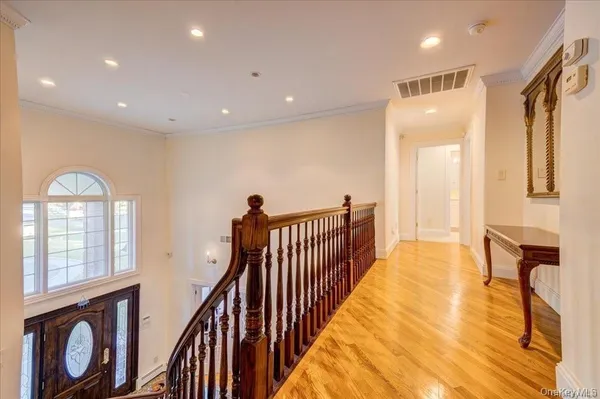 a view of a hallway with wooden floor and furniture