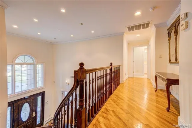 a view of a hallway with wooden floor and furniture