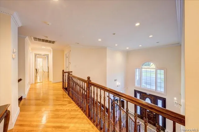 a view of a hallway with wooden floor and staircase