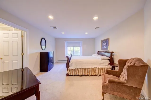 a spacious bedroom with a bed and dresser