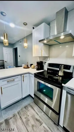 a kitchen with stainless steel appliances a stove a sink and cabinets