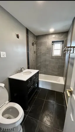 a bathroom with a sink vanity granite toilet and a mirror