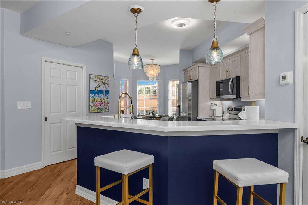 451 Bayfront Place, Unit 5201 Naples, FL 34102 - Photo 11 of 38 a kitchen with cabinets a sink stainless steel appliances and chairs