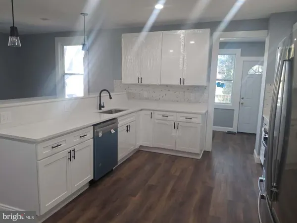 a kitchen with a sink cabinets and wooden floor