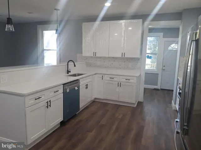 a kitchen with a sink cabinets and wooden floor