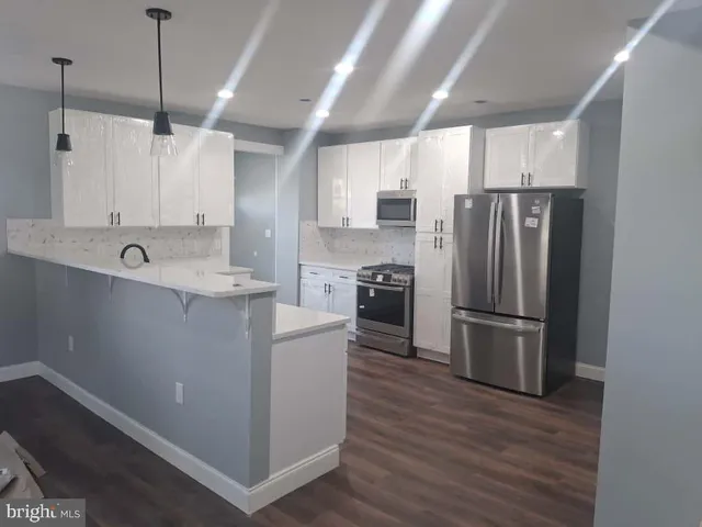 a kitchen with kitchen island a sink stainless steel appliances and cabinets