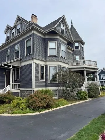 a front view of a house with a yard and potted plants