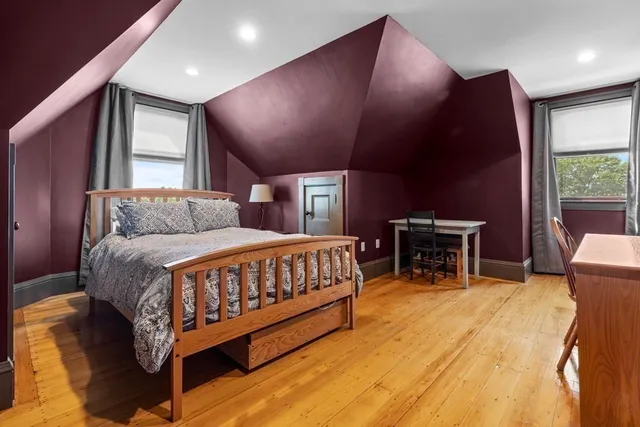 a bedroom with a bed mirror and a window