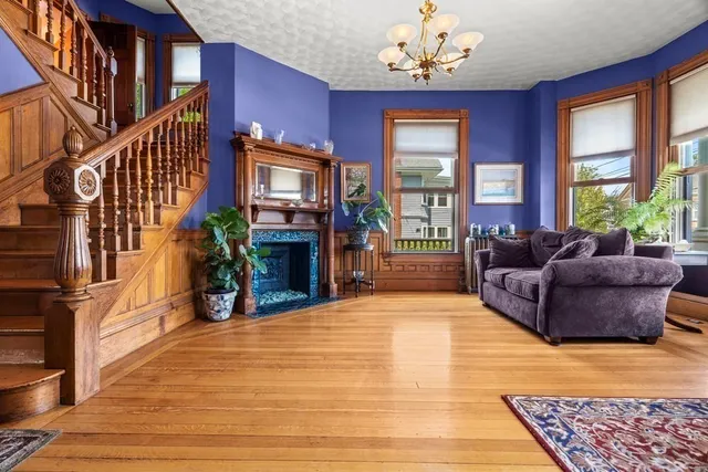 a living room with furniture a fireplace and a chandelier