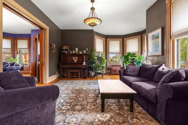 a living room with furniture a chandelier and a window