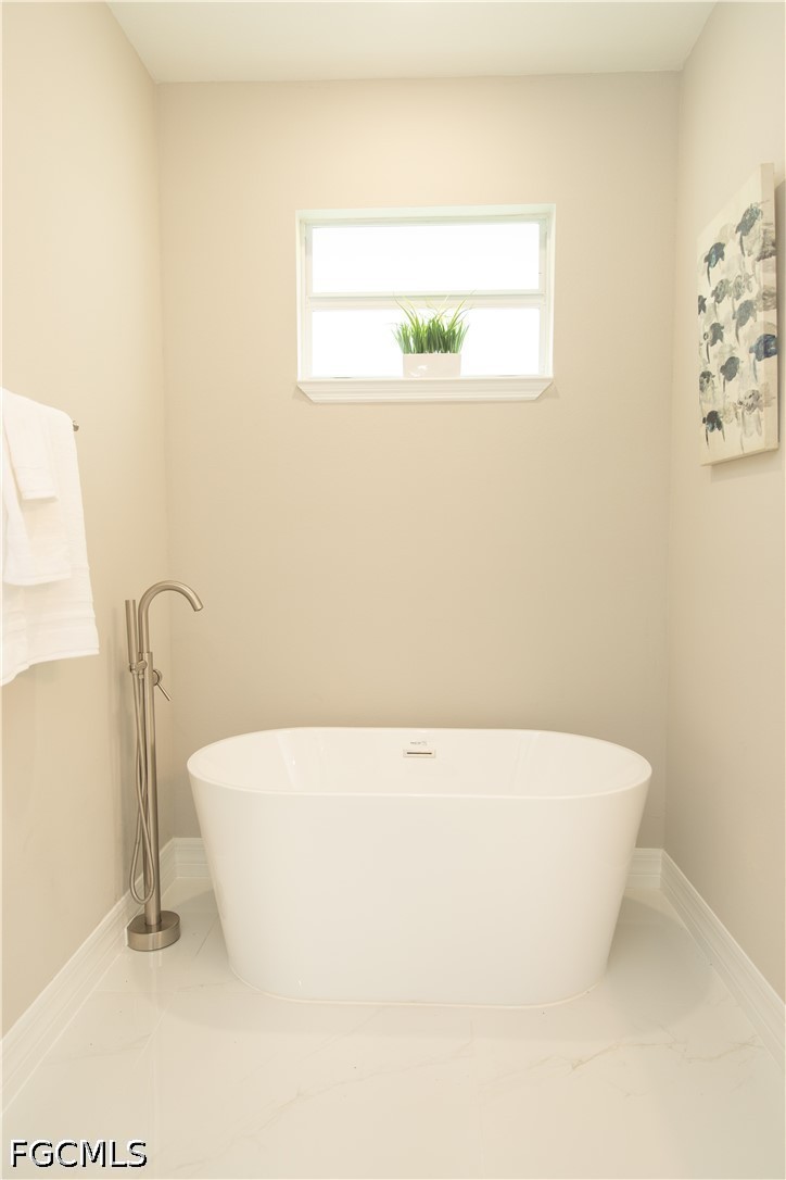 1228 Chrisholm Street Lehigh Acres, FL 33974 - Photo 13 of 18 a white tub sitting in a bathroom