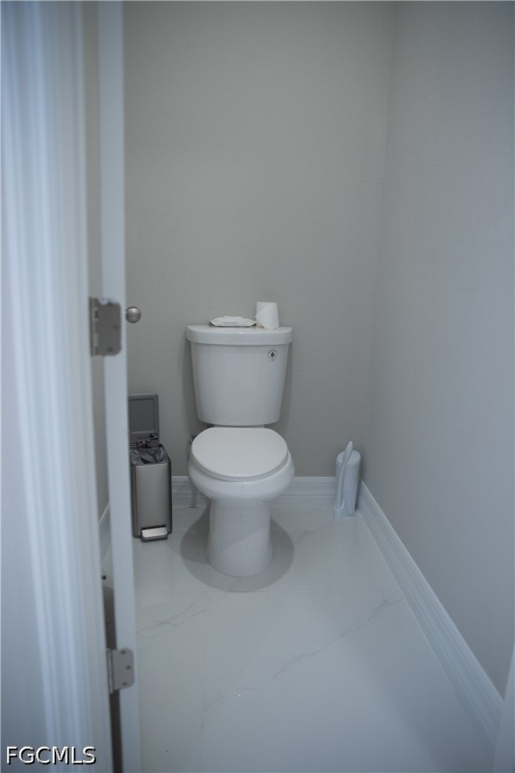 1228 Chrisholm Street Lehigh Acres, FL 33974 - Photo 16 of 18 a white toilet sitting next to a shower