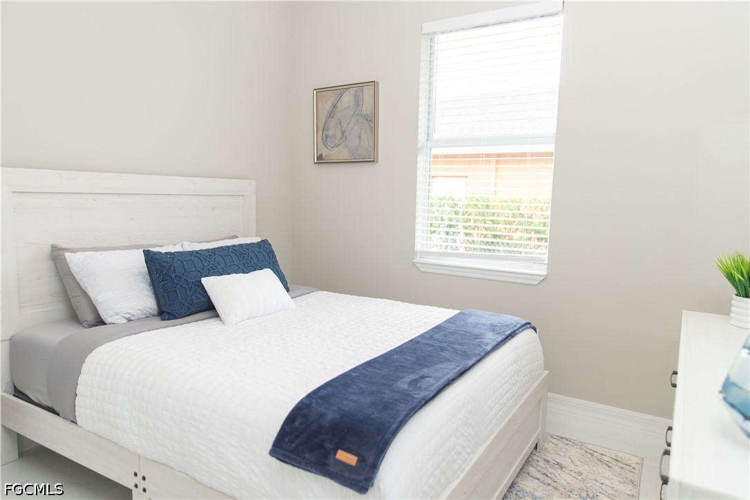 1228 Chrisholm Street Lehigh Acres, FL 33974 - Photo 7 of 18 a bedroom with a bed and a window