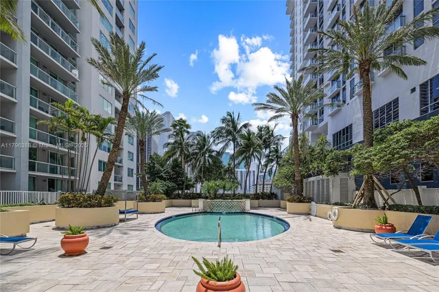 a view of a backyard with swimming pool and sitting area