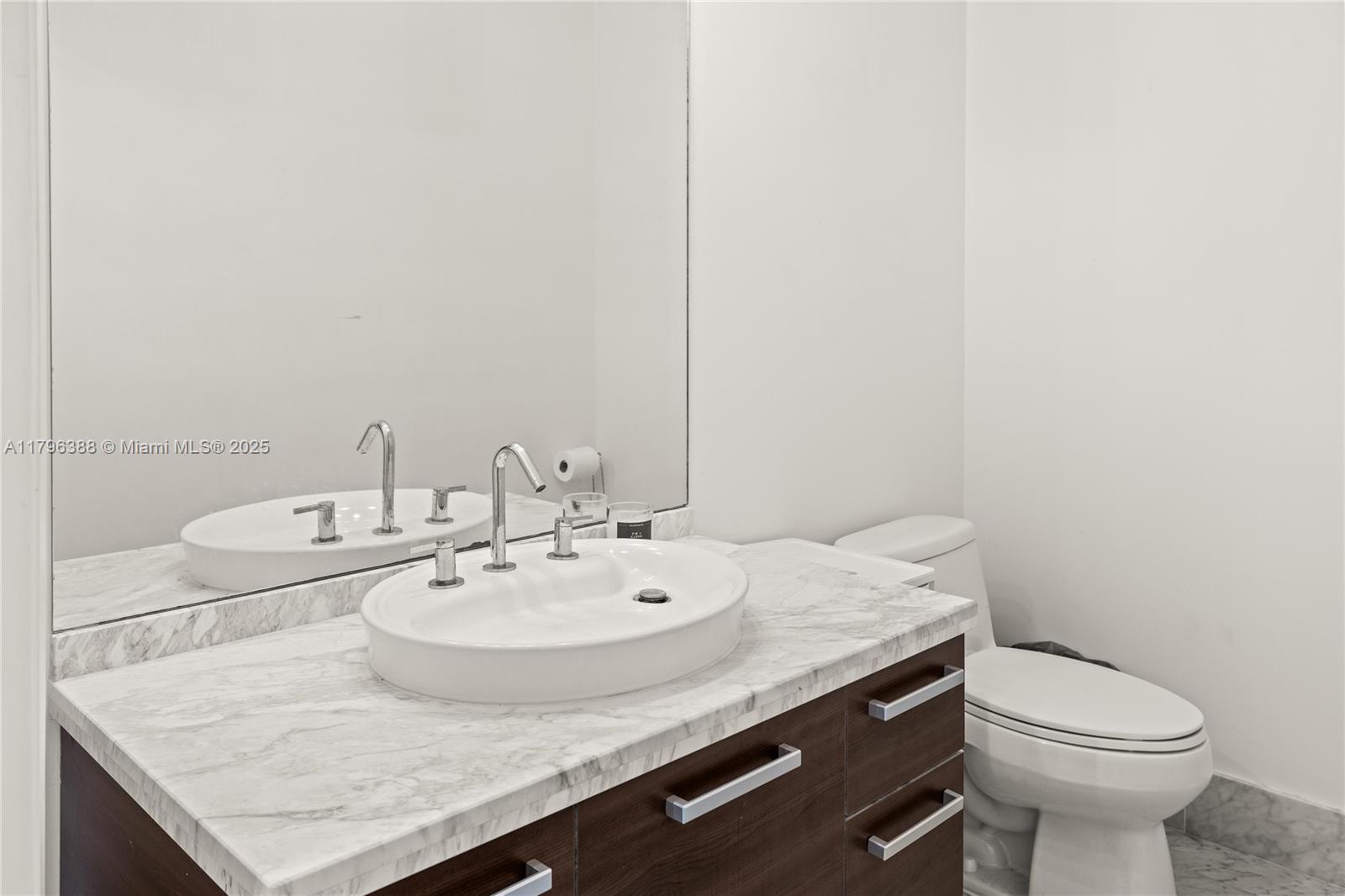 244 Biscayne Boulevard, Unit 645 Miami, FL 33132 - Photo 4 of 45 a bathroom with a granite countertop sink and a toilet