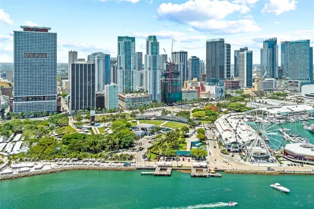 a front view of multi story residential apartment building with yard and sign board