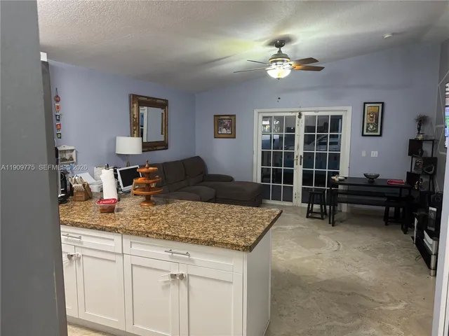 a living room with granite countertop furniture and a chandelier