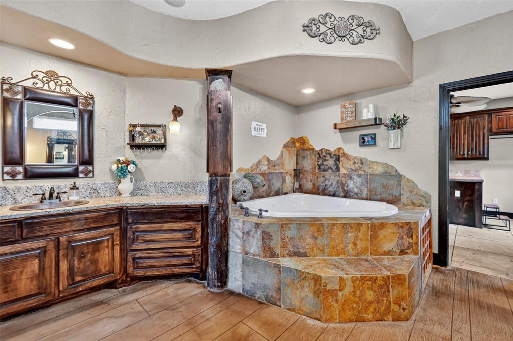 1717 Batey Road Collinsville, TX 76233 - Photo 21 of 40 a spacious bathroom with a granite countertop sink a mirror and bathtub