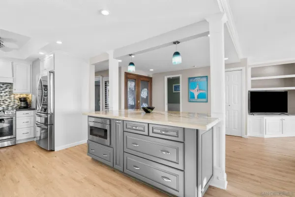 a spacious kitchen with stainless steel appliances kitchen island granite countertop a refrigerator and a stove top oven