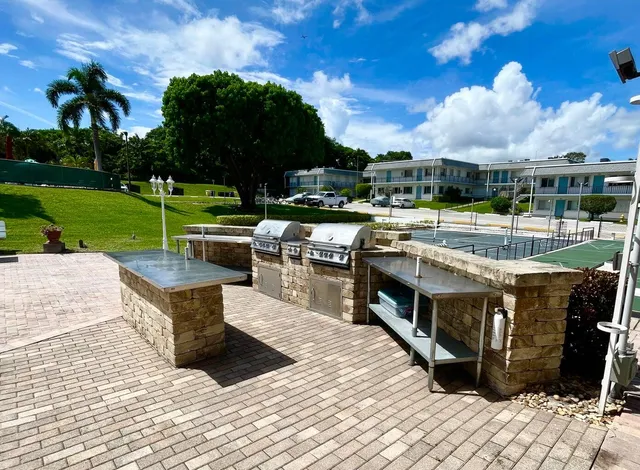 a view of a swimming pool with lawn chairs and a big yard