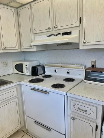 a view of a kitchen with white cabinets
