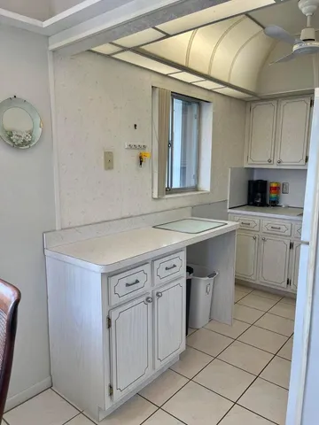 a kitchen with white cabinets and sink
