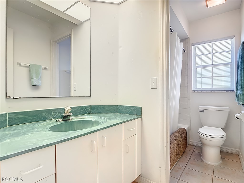2160 Faliron Road North Fort Myers, FL 33917 - Photo 21 of 42 a bathroom with a granite countertop sink a toilet and a mirror