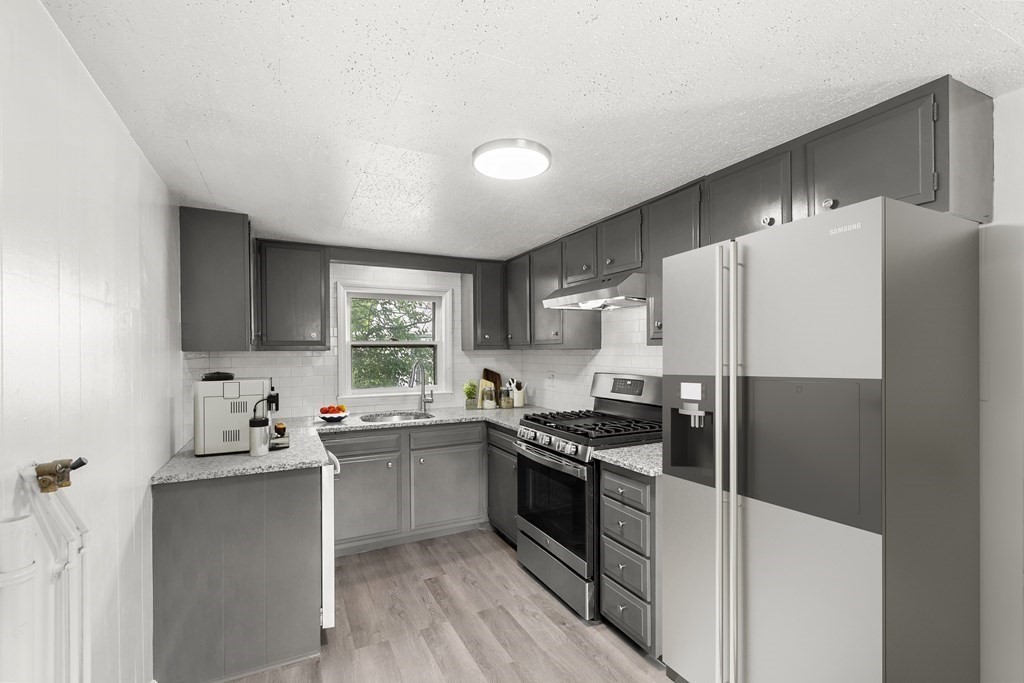 28 Stevens Street, Unit B Methuen, MA 01844 - Photo 7 of 11 a kitchen with a sink a refrigerator and white cabinets