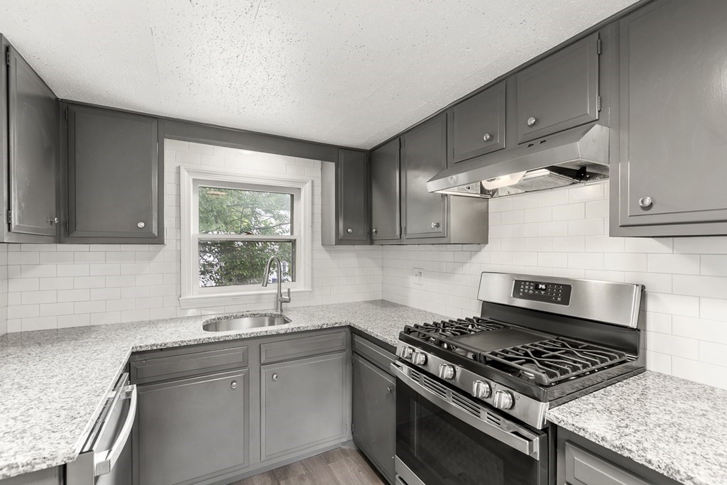 28 Stevens Street, Unit B Methuen, MA 01844 - Photo 8 of 11 a kitchen with granite countertop a stove and a sink
