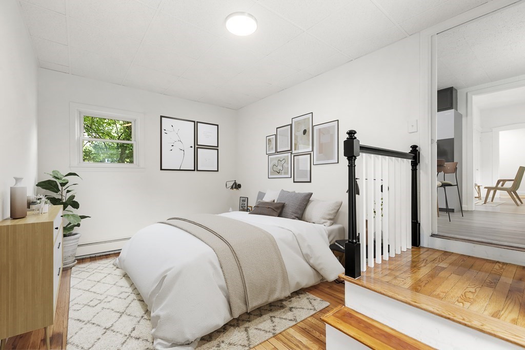 28 Stevens Street, Unit B Methuen, MA 01844 - Photo 9 of 11 a bedroom with a bed table and a potted plant