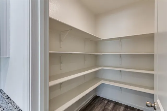 an empty room with windows and a kitchen