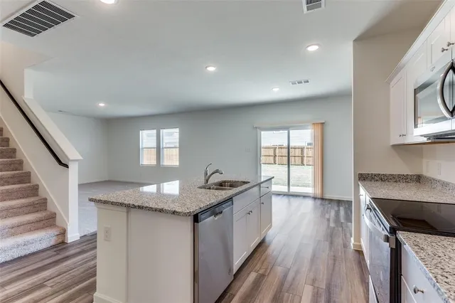 a view of kitchen with granite countertop cabinets and wooden floor