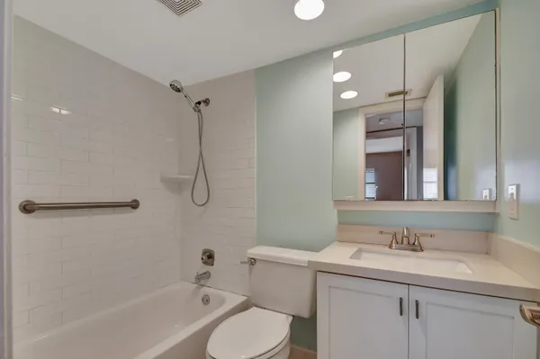 a bathroom with a granite countertop sink toilet and shower