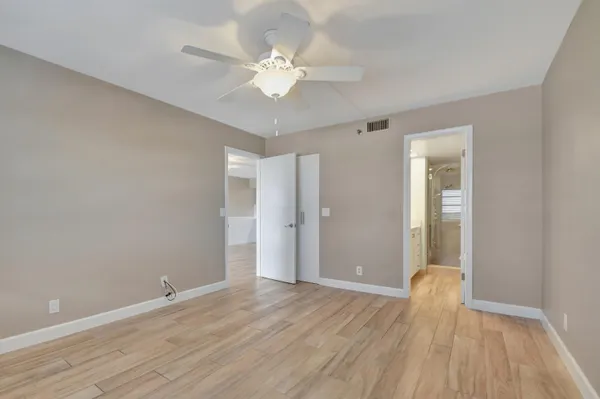 a view of an empty room with wooden floor