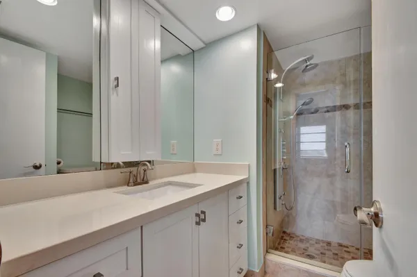 a bathroom with a shower sink and mirror