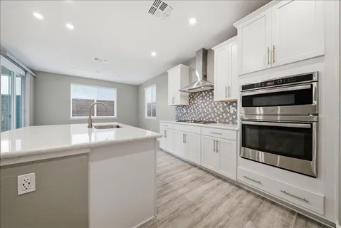 a kitchen with stainless steel appliances granite countertop a sink and a stove